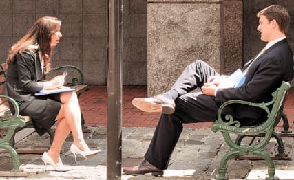 Man and woman talking on a bench.