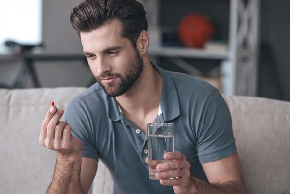 A guy about to take the pill