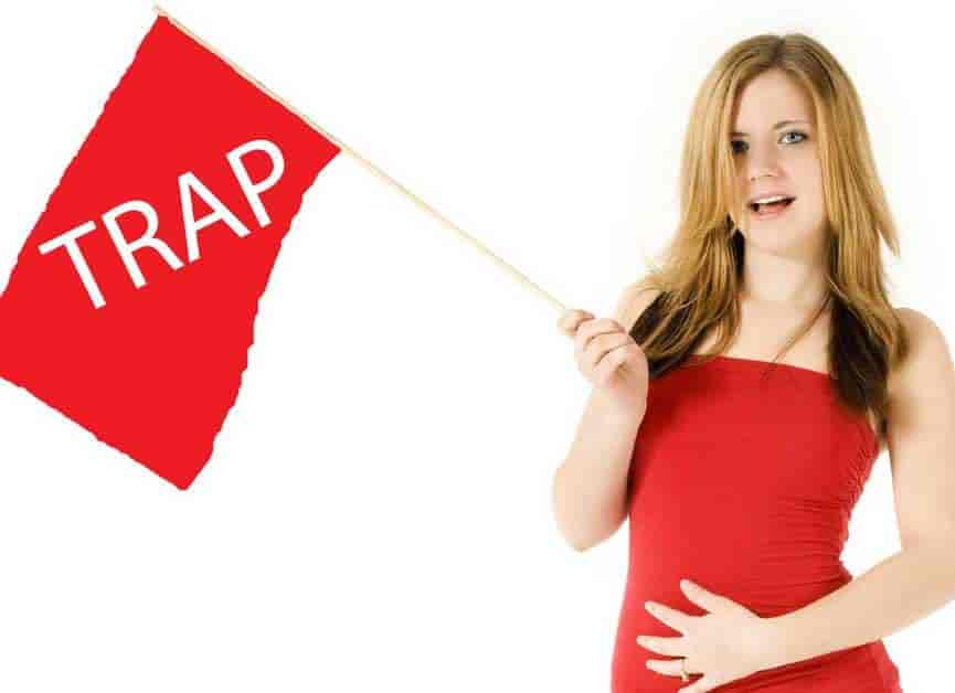 woman holding red flag that says "Trap".