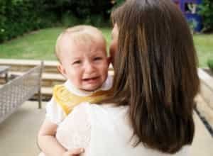 A single motherm holding a crying boy