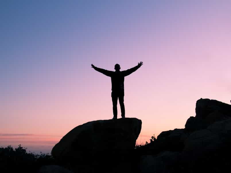 A man standing on rock feeling freedom
